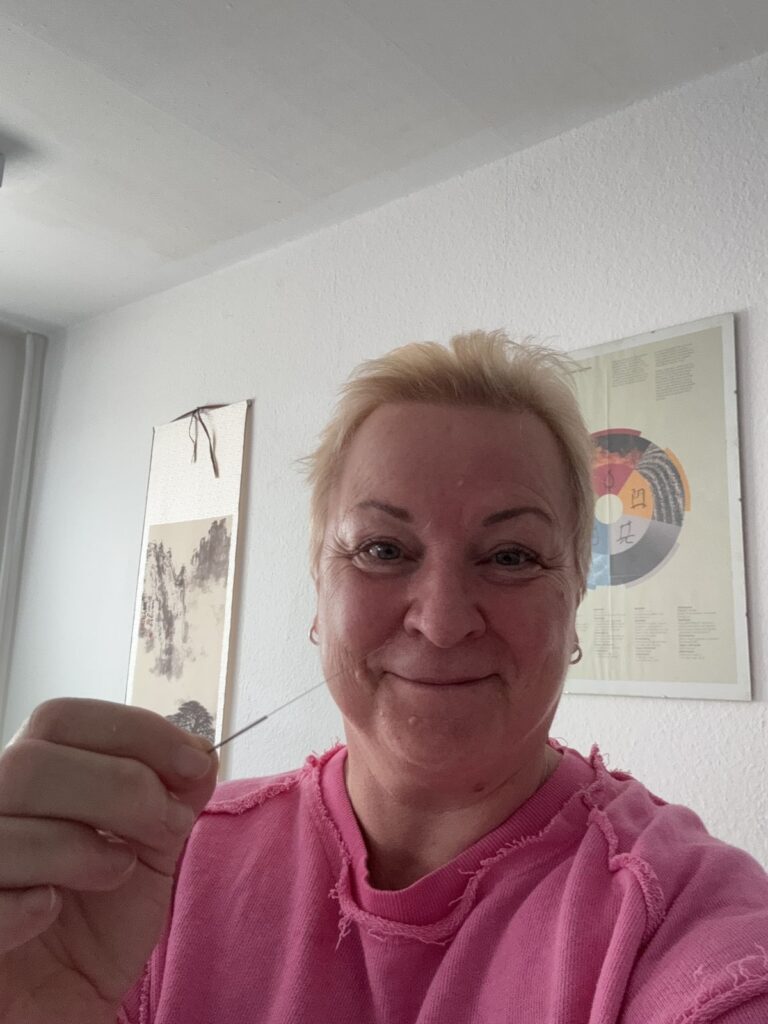 Kira Schwarzrock in der Praxis mit einer Akupunkturnadel